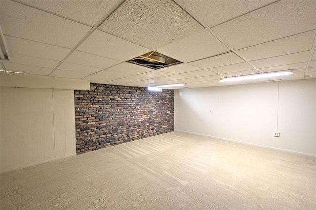 finished basement featuring visible vents, carpet, a paneled ceiling, and baseboards