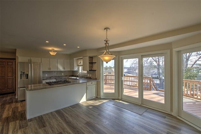 kitchen with dark wood finished floors, white cabinets, a sink, a peninsula, and stainless steel fridge with ice dispenser