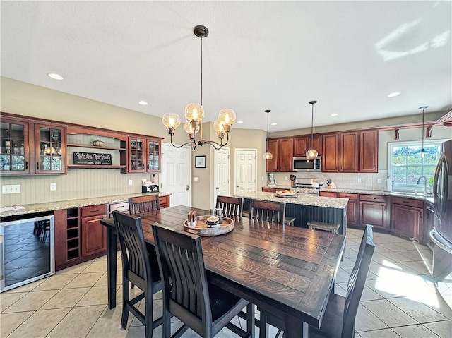 dining area featuring light tile patterned floors, wine cooler, an inviting chandelier, and recessed lighting