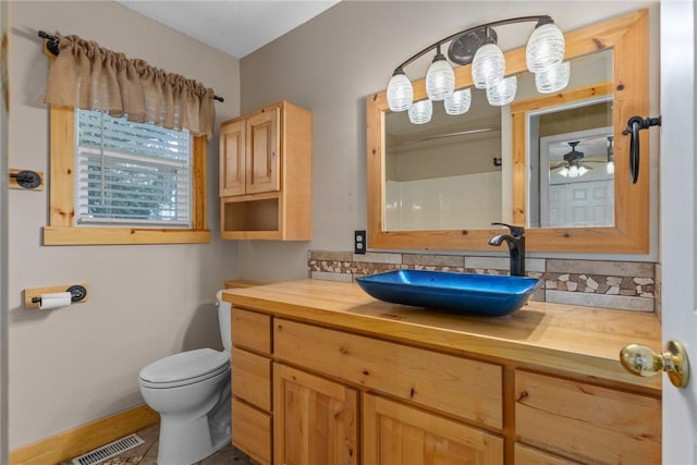 510 N Merchant St, Effingham, IL 62401 - bathroom featuring toilet, vanity, ceiling fan, and baseboards