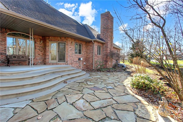 508 Deere Run Ln, Casey, IL 62420 - rear view of house with a patio, brick siding, roof with shingles, and a chimney