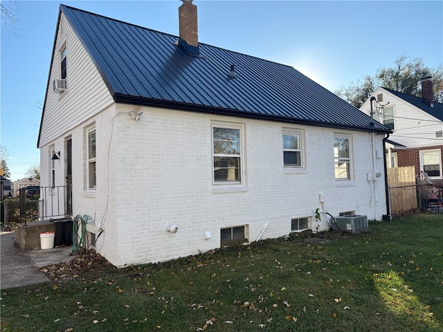 rear view of property featuring a yard and central AC