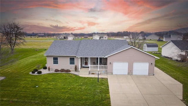 ranch-style house featuring a porch, a lawn, and a garage