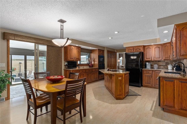 1003 Flame Ave, Effingham, IL 62401 - kitchen with black appliances, brown cabinets, a kitchen island, light stone counters, and backsplash