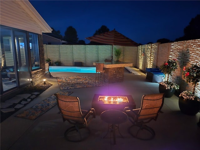 1003 Flame Ave, Effingham, IL 62401 - patio at twilight featuring a patio, a fire pit, and a fenced backyard