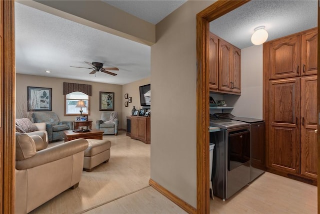 1003 Flame Ave, Effingham, IL 62401 - laundry area featuring washing machine and clothes dryer, ceiling fan, a textured ceiling, cabinet space, and light wood-style floors