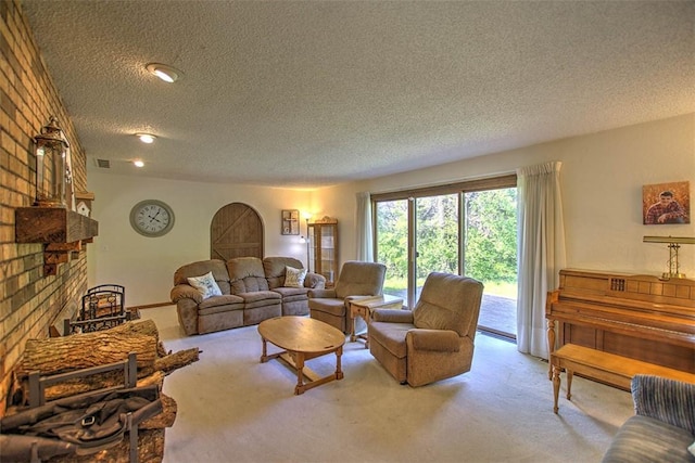 carpeted living room featuring a textured ceiling, visible vents, and a fireplace