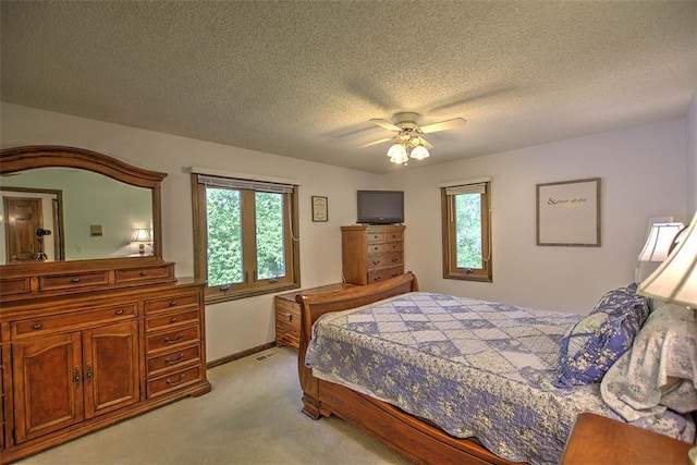 bedroom with light carpet, a textured ceiling, and ceiling fan