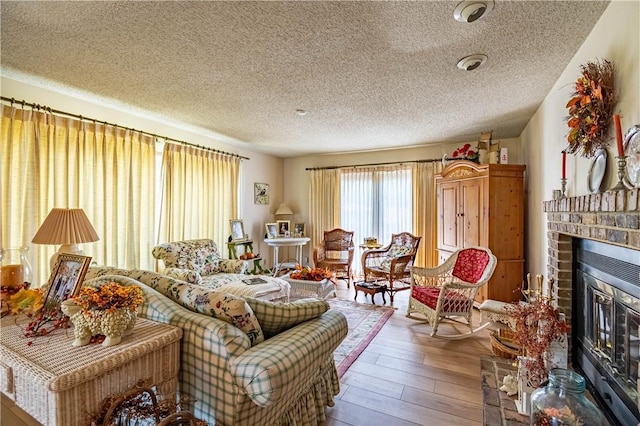 1059 Columbia Dr, Decatur, IL 62522 - living room with a brick fireplace, a textured ceiling, and hardwood / wood-style flooring