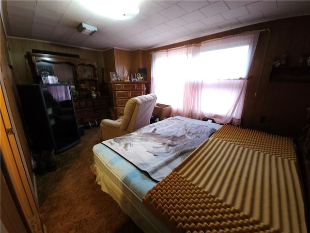 bedroom with wood walls and carpet