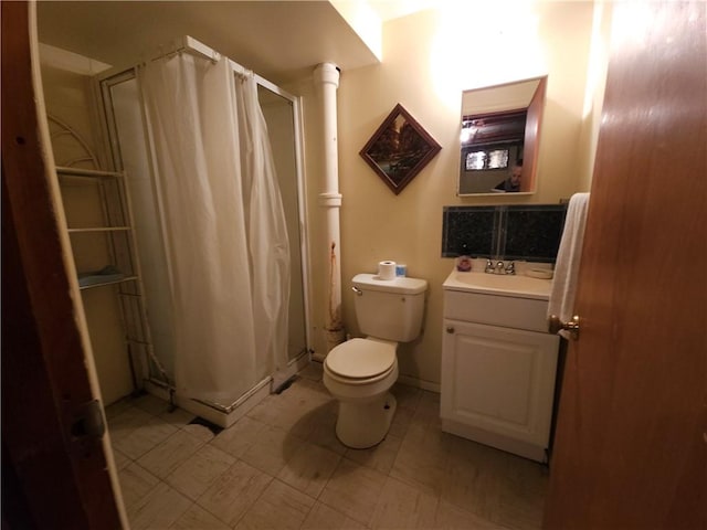 bathroom with vanity, a shower stall, and toilet