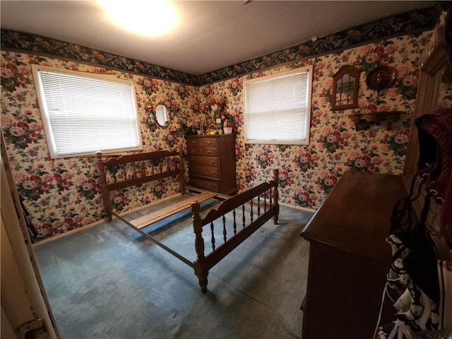 bedroom featuring wallpapered walls, baseboards, and dark colored carpet