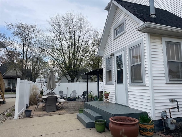 view of side of property with outdoor dining space, a patio area, and fence
