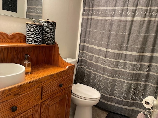 bathroom featuring curtained shower, vanity, and toilet