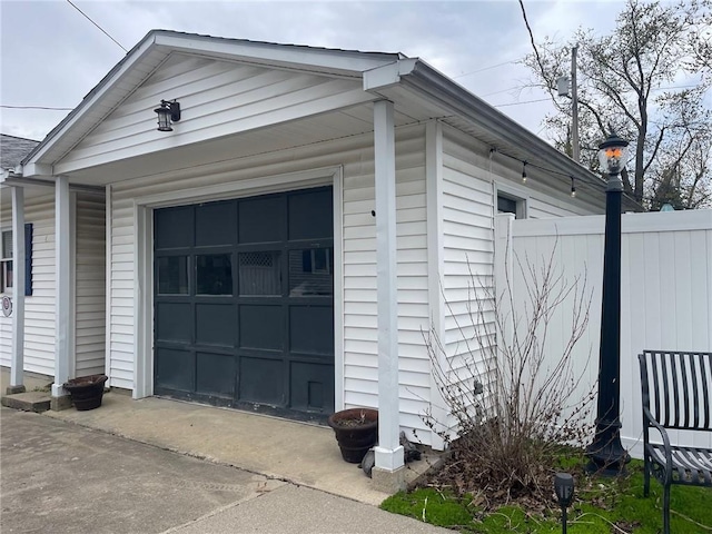 view of side of property featuring an outbuilding, fence, and a garage