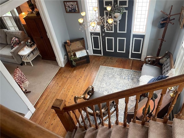 foyer entrance with a healthy amount of sunlight, wood-type flooring, baseboards, and stairs