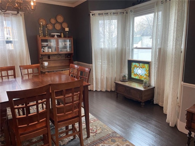 dining area featuring wood finished floors, a notable chandelier, and ornamental molding