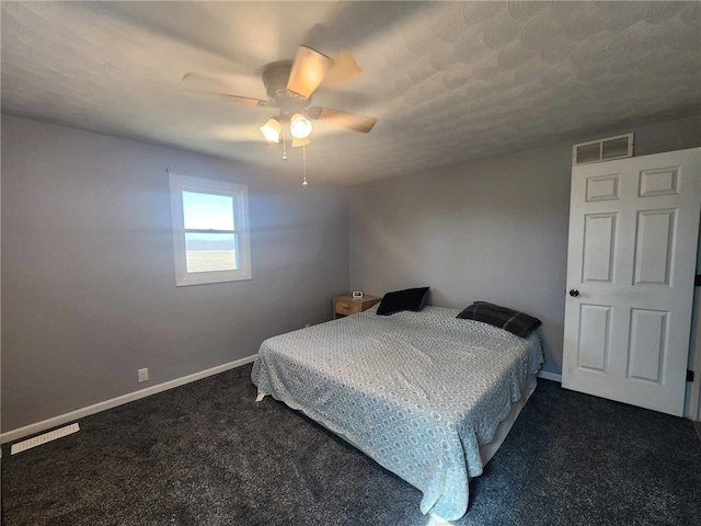 bedroom with baseboards, visible vents, dark colored carpet, and a ceiling fan