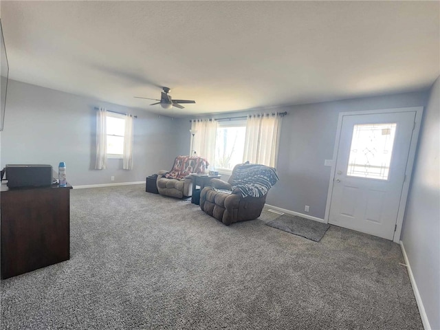 carpeted living room featuring ceiling fan and baseboards