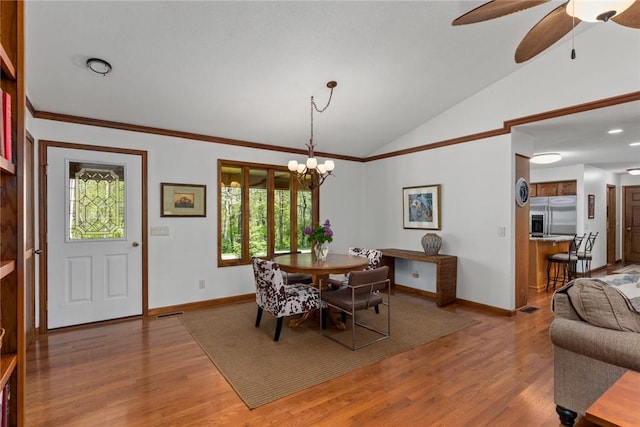 dining area featuring crown molding, baseboards, light wood-style flooring, ceiling fan with notable chandelier, and vaulted ceiling