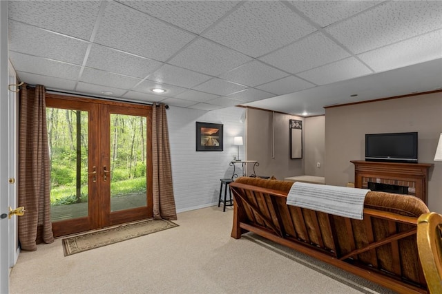 carpeted bedroom with french doors, baseboards, a drop ceiling, and access to outside