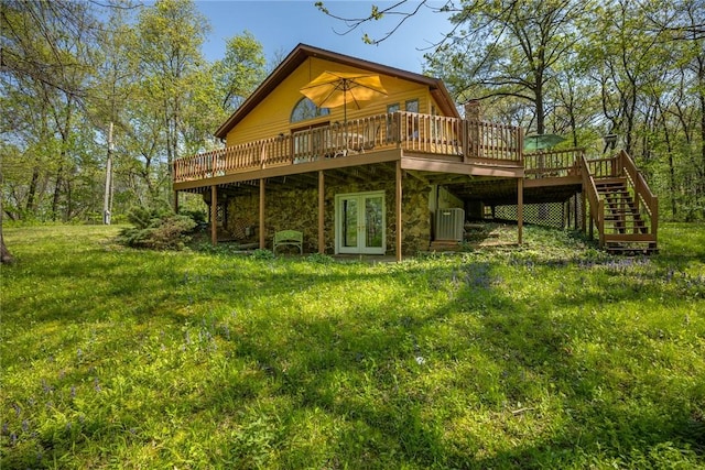 rear view of house featuring a deck, french doors, stairs, and stone siding