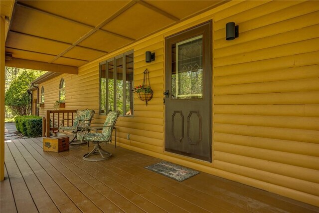view of exterior entry featuring covered porch