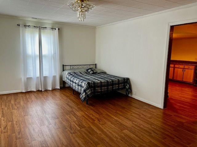 311 E Collett St, Oakwood, IL 61858 - bedroom with ornamental molding, wood finished floors, and a chandelier