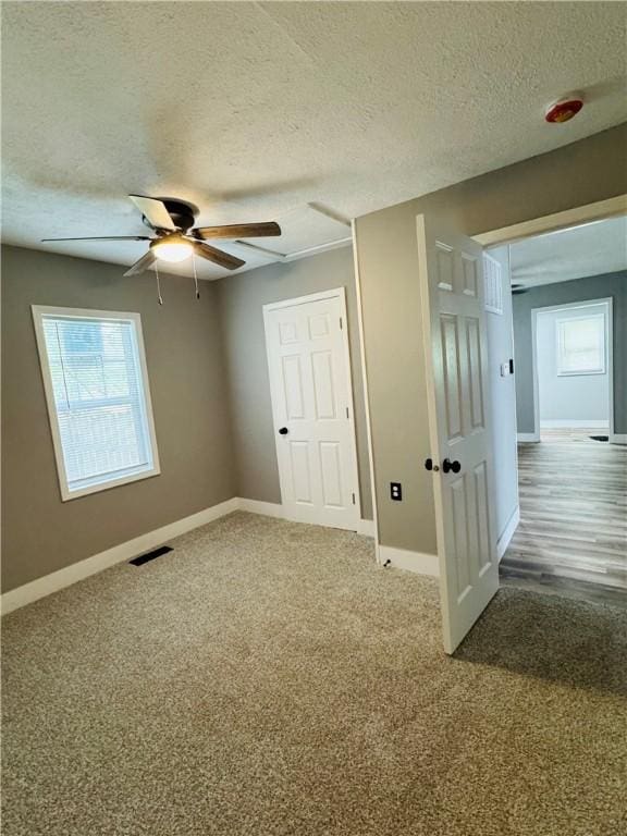 1404 N 24th St, Decatur, IL 62526 - unfurnished bedroom featuring a textured ceiling, baseboards, carpet, and a ceiling fan