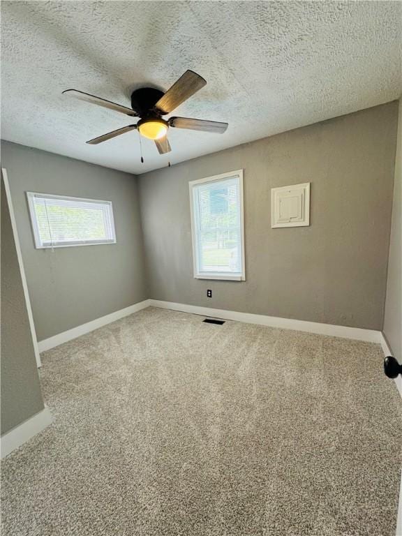 1404 N 24th St, Decatur, IL 62526 - unfurnished room with ceiling fan, carpet, baseboards, and a textured ceiling