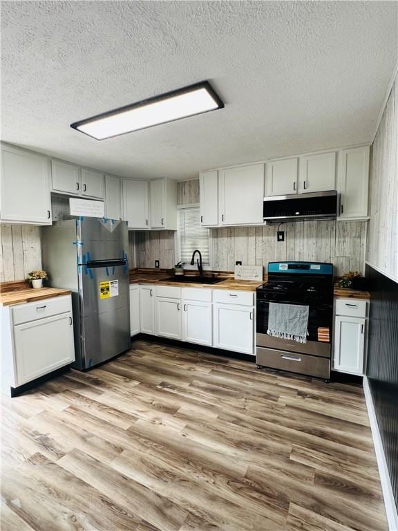 1404 N 24th St, Decatur, IL 62526 - kitchen featuring appliances with stainless steel finishes, ventilation hood, butcher block countertops, a sink, and wood finished floors