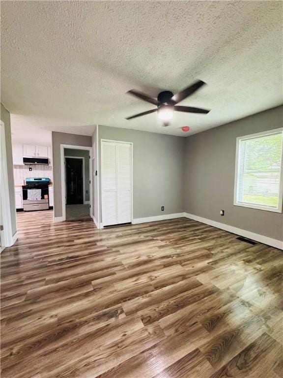 1404 N 24th St, Decatur, IL 62526 - unfurnished bedroom featuring baseboards, wood finished floors, a textured ceiling, a closet, and ceiling fan