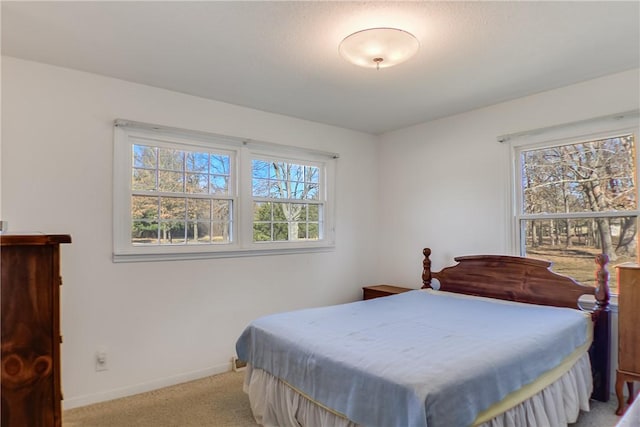 bedroom with light colored carpet and baseboards