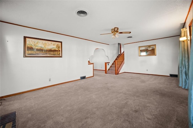 801 N Central Ave, Paris, IL 61944 - unfurnished living room featuring crown molding, carpet flooring, a ceiling fan, stairs, and arched walkways