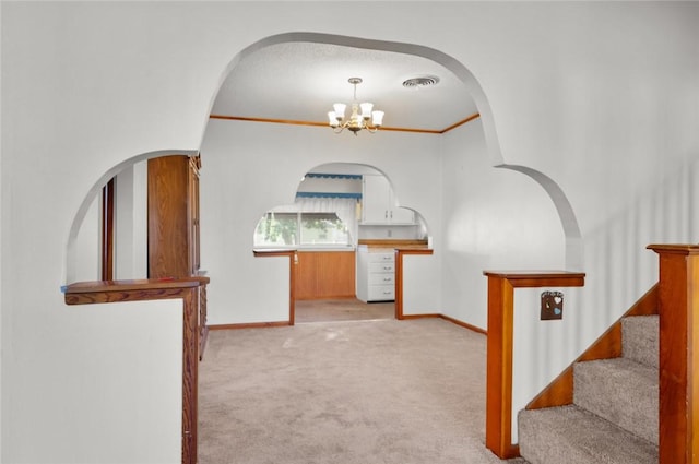801 N Central Ave, Paris, IL 61944 - hall with light colored carpet, a chandelier, stairway, and crown molding