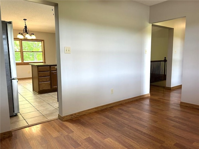 3002 N Charlotte St, Effingham, IL 62401 - empty room featuring light wood-style flooring, a chandelier, and baseboards