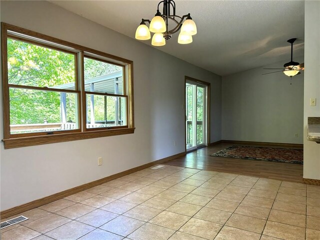 3002 N Charlotte St, Effingham, IL 62401 - unfurnished room with a chandelier, baseboards, lofted ceiling, light tile patterned flooring, and ceiling fan