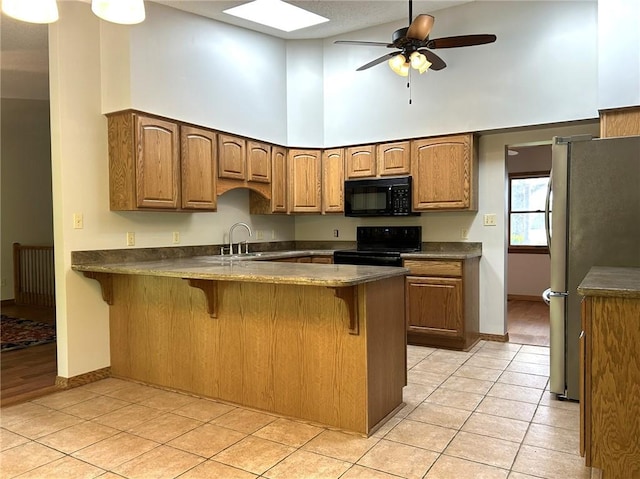 3002 N Charlotte St, Effingham, IL 62401 - kitchen featuring black appliances, high vaulted ceiling, a peninsula, a breakfast bar area, and baseboards