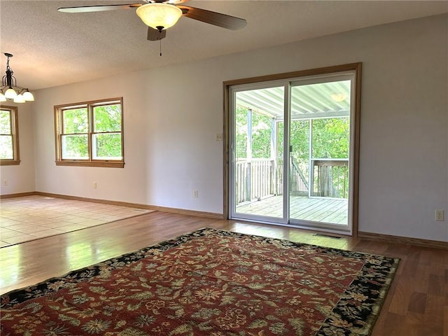 3002 N Charlotte St, Effingham, IL 62401 - unfurnished room featuring wood finished floors, a ceiling fan, baseboards, and a chandelier
