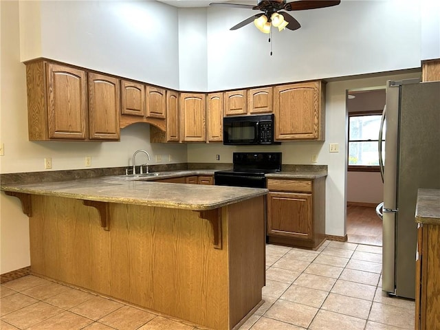 3002 N Charlotte St, Effingham, IL 62401 - kitchen with black appliances, a high ceiling, a sink, light tile patterned floors, and a peninsula