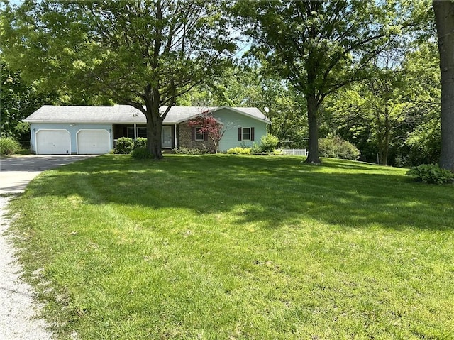 3002 N Charlotte St, Effingham, IL 62401 - ranch-style house featuring an attached garage, driveway, a front lawn, and view of wooded area
