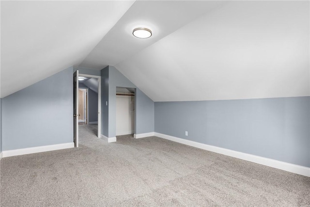 additional living space featuring lofted ceiling and light colored carpet