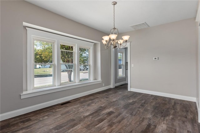 unfurnished dining area featuring an inviting chandelier and dark hardwood / wood-style floors