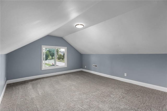 bonus room with vaulted ceiling and carpet floors