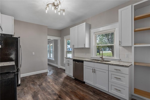 kitchen with appliances with stainless steel finishes, white cabinetry, backsplash, and sink