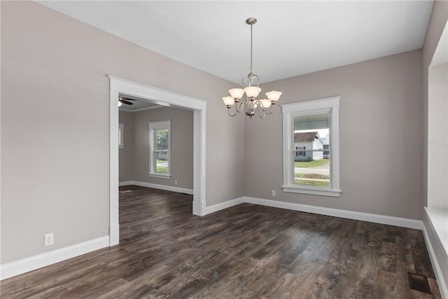 empty room featuring ceiling fan with notable chandelier and dark hardwood / wood-style floors