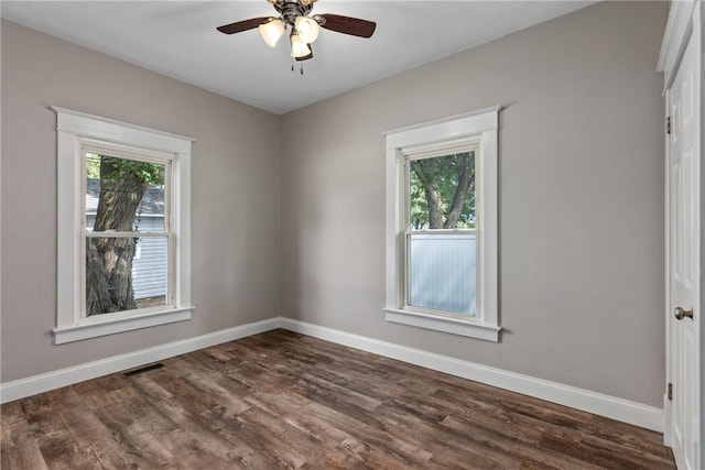 unfurnished room featuring dark hardwood / wood-style flooring, ceiling fan, and plenty of natural light