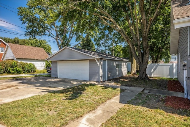 exterior space featuring a front lawn, a garage, and an outdoor structure