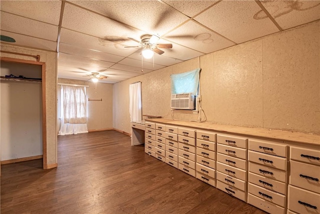 basement featuring a paneled ceiling, cooling unit, and dark wood-type flooring