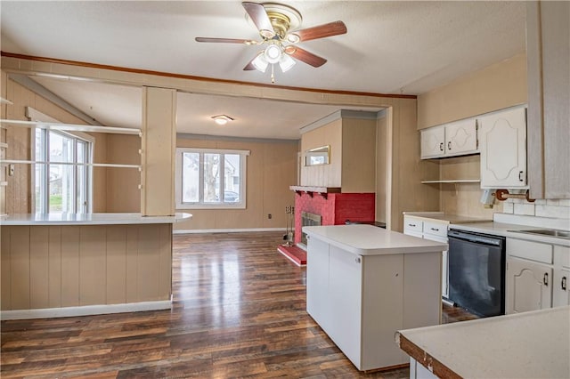 kitchen featuring a wealth of natural light, dishwasher, a kitchen island, and wooden walls